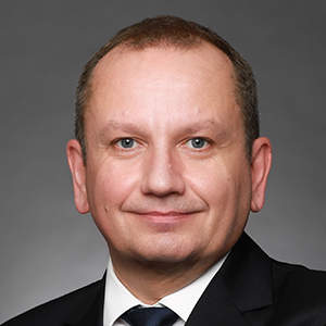 A professional portrait of an adult businessman, showcasing a confident and focused expression in a business setting.