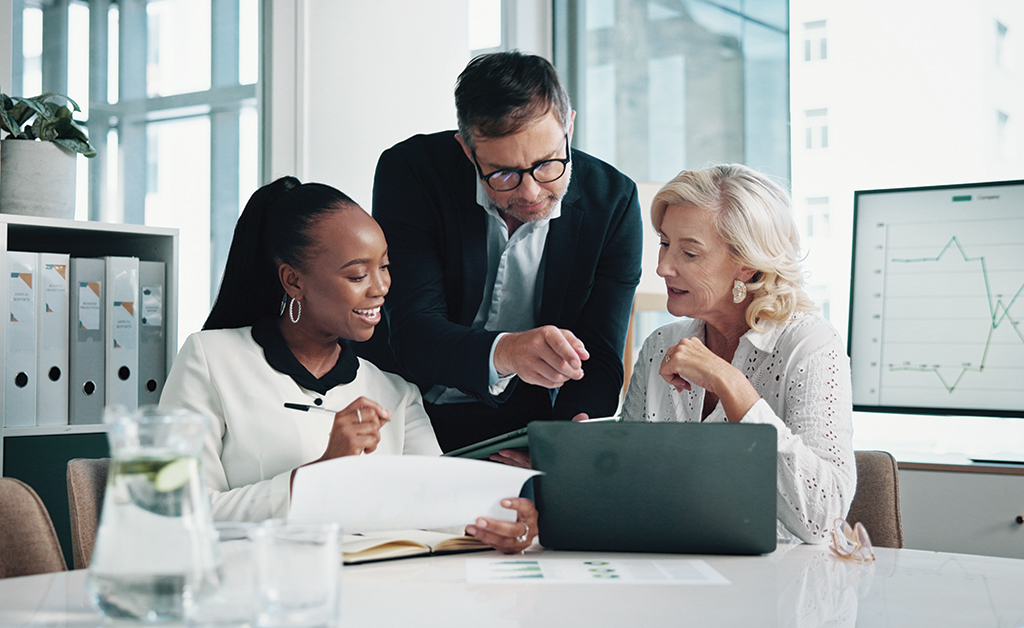 A group of business professionals collaborates in an office meeting, showcasing teamwork and productive discussion.