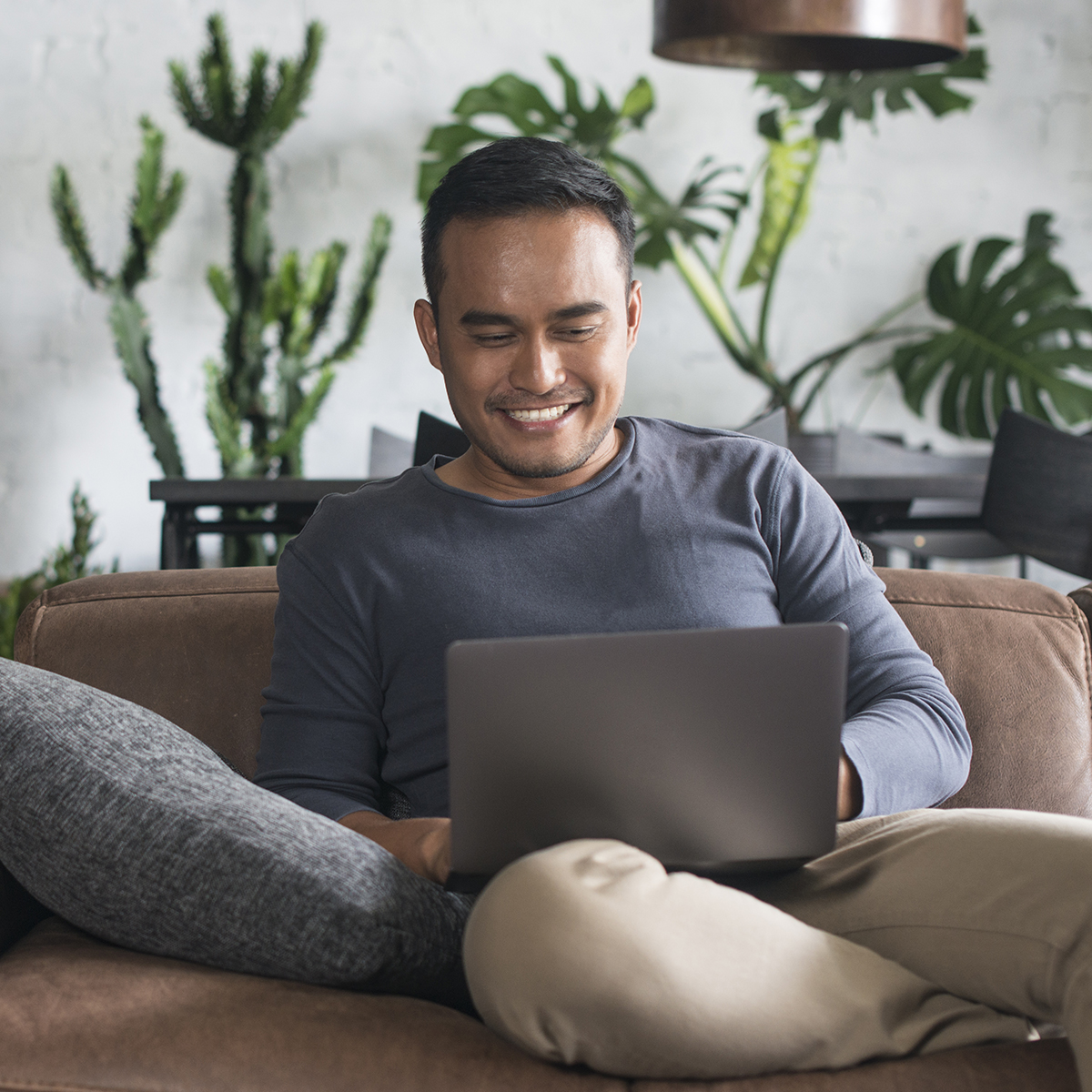A smiling man looking at his laptop