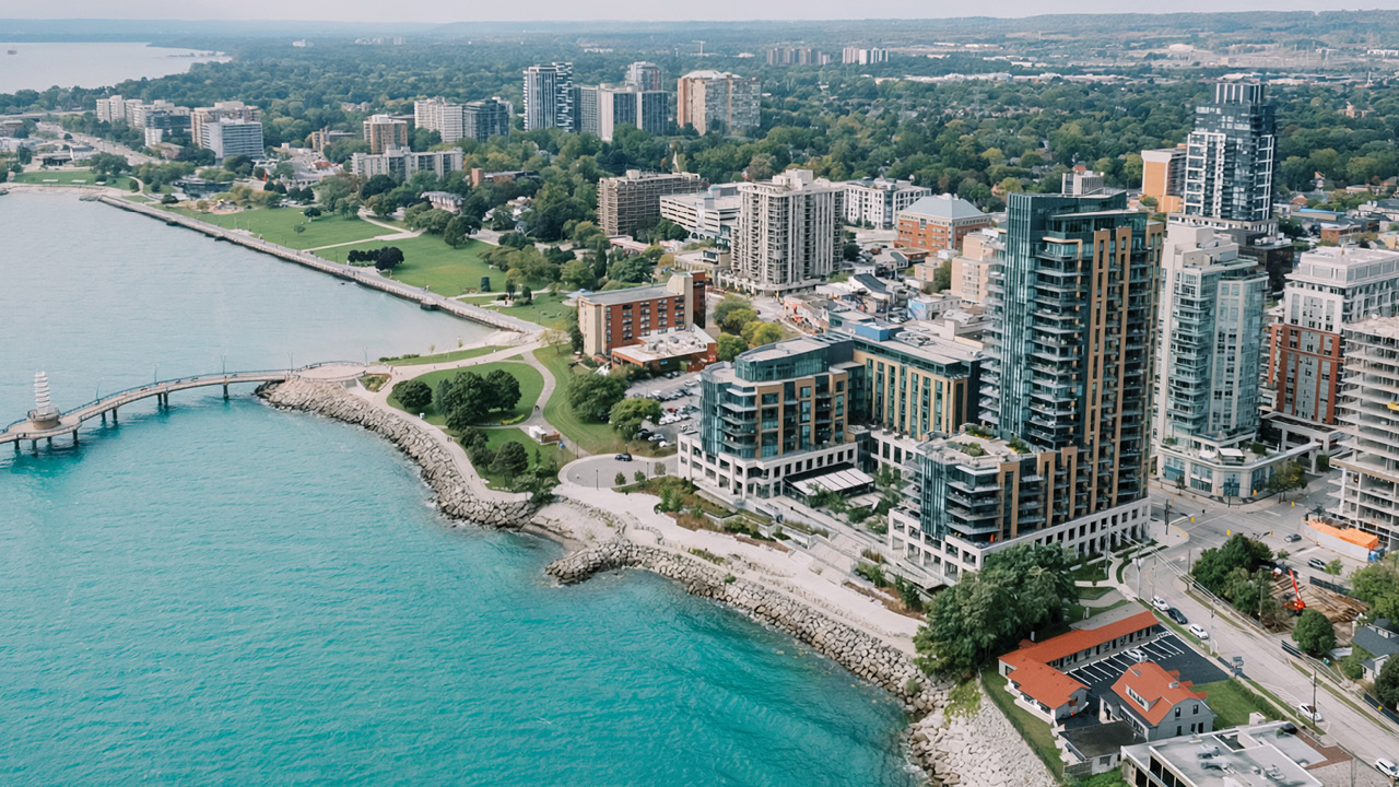 Aerial view of a coastal city shoreline and inlet, highlighting downtown skyline, waterfront resorts, and urban landscape.