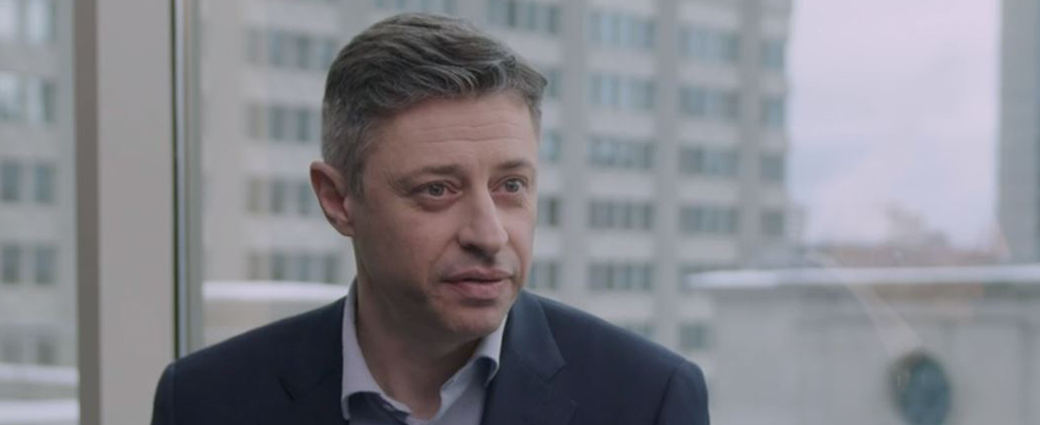 Un portrait professionnel mettant en scène un jeune homme d'affaires concentré sur son travail dans un cadre de bureau.