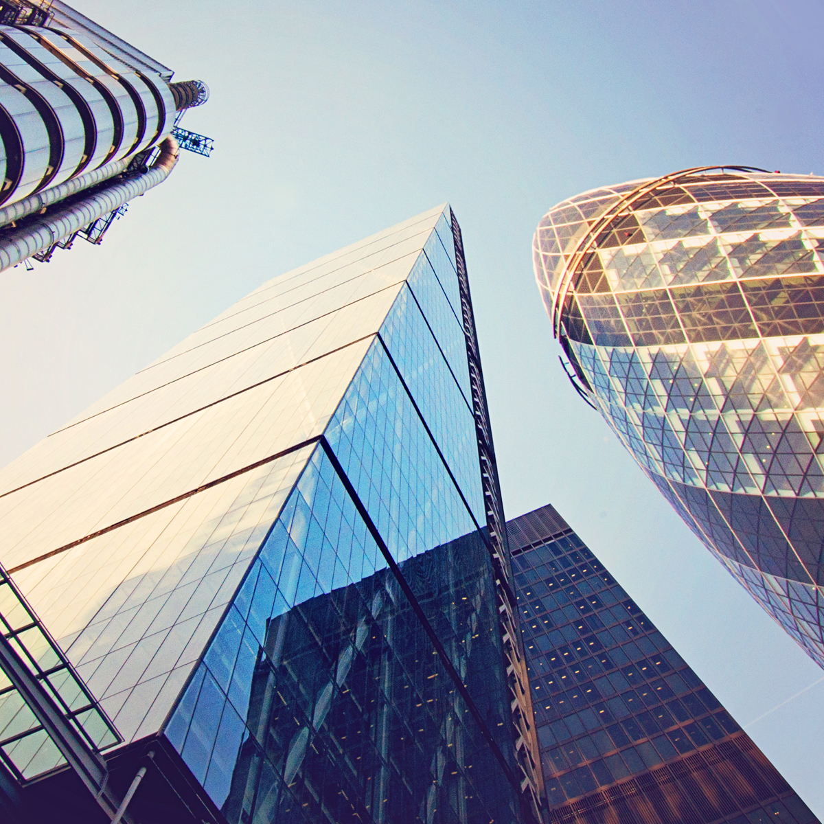Cityscape photo of a downtown square featuring corporate commercial building facades and skyscrapers in a modern metropolis.