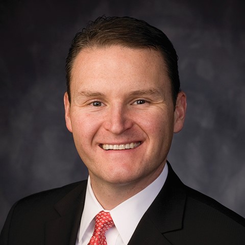 Portrait of a professional adult businessman, a confident white male, captured in a neutral and business-focused setting.