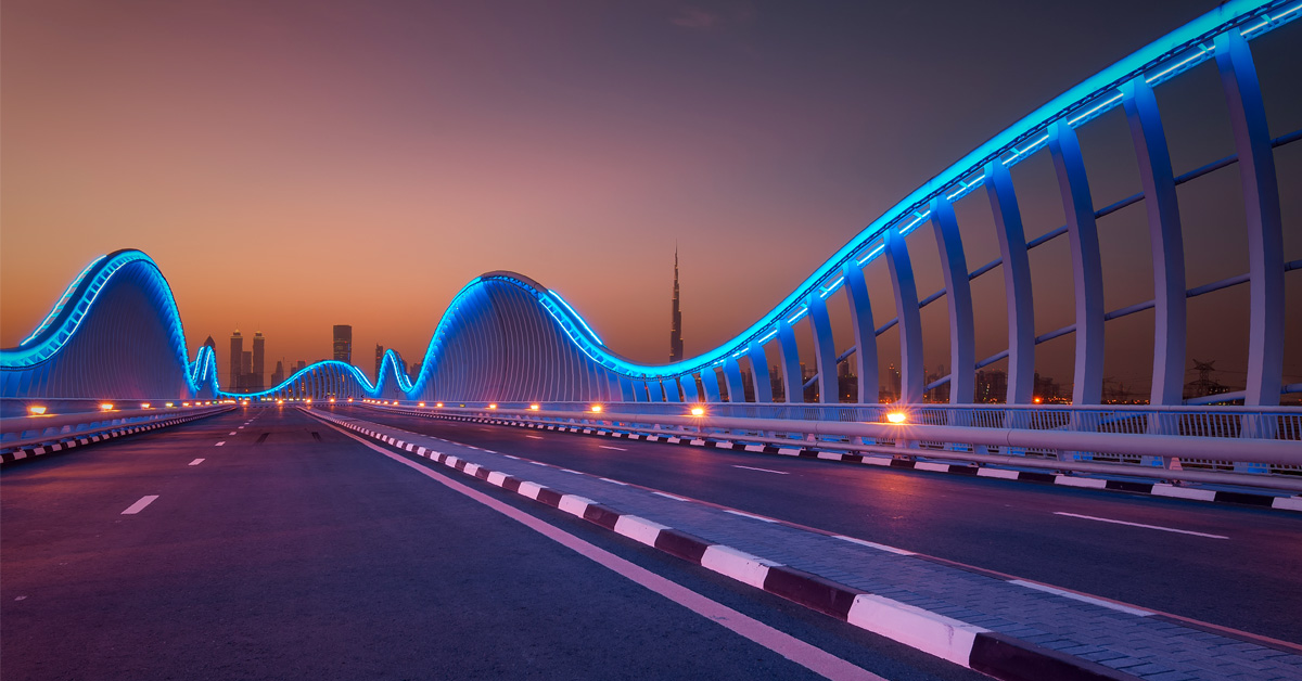 Highway bridge at night, lit with colorful lights for nighttime (as opposed to daytime) driving