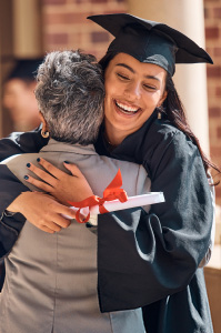 Graduate celebration, hugging parent.