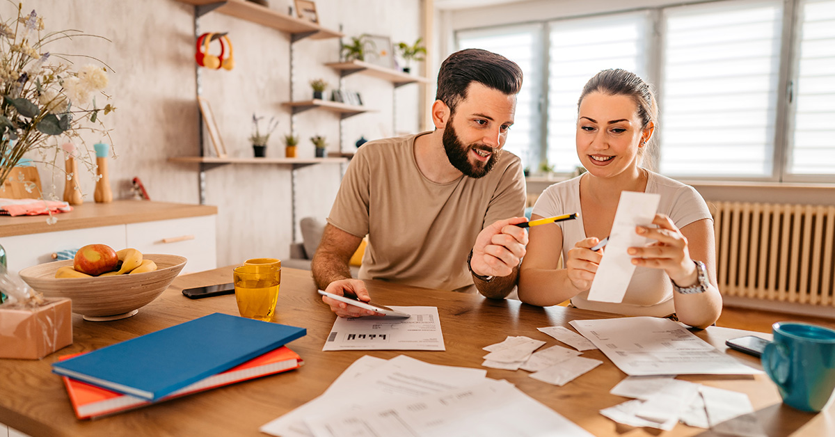 Un couple satisfait, tous deux des professionnels aguerris, travaille joyeusement ensemble depuis leur bureau à domicile.