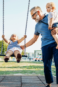 Des enfants partagent un moment de joie et de complicité dans un parc, reflétant les liens forts et l'harmonie familiale.
