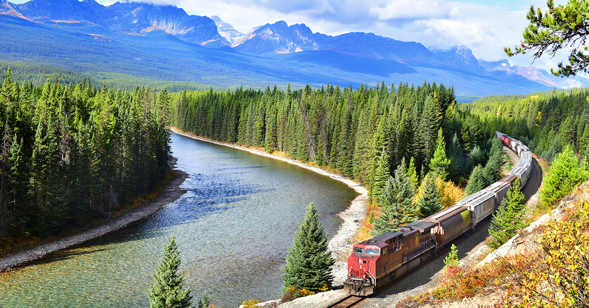 Ce paysage représente un mélange harmonieux des éléments de la nature - la forêt verdoyante, le ciel bleu, le lac serein et les montagnes majestueuses.