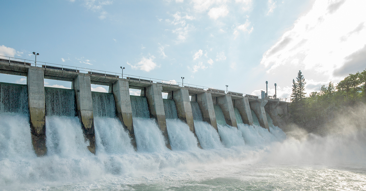 The powerful cascade of the dam creates a stunning waterfall, showcasing the beauty of nature in the landscape.