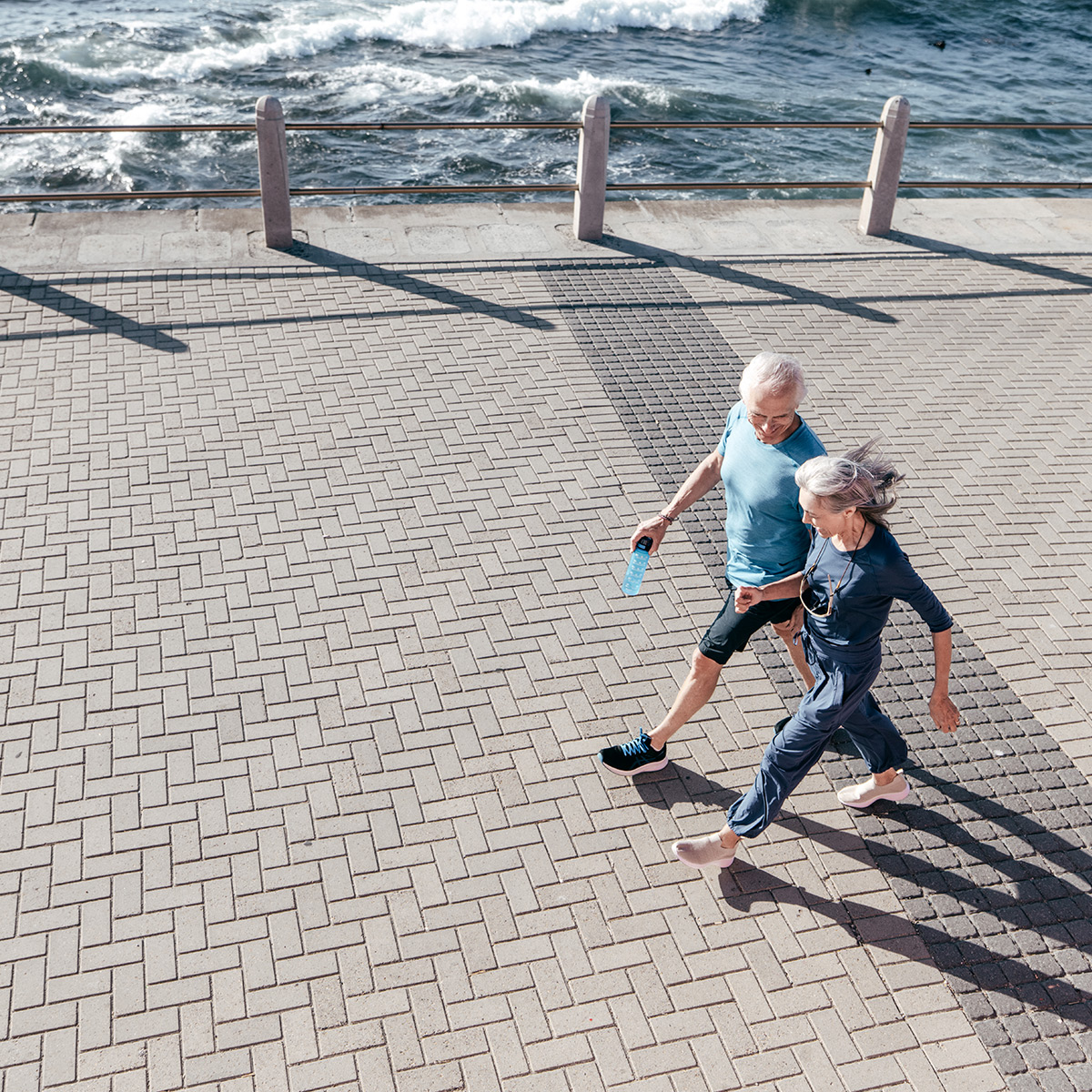 Pedestrians walk and run through a city square promenade, a lifestyle photo capturing weekday urban movement.