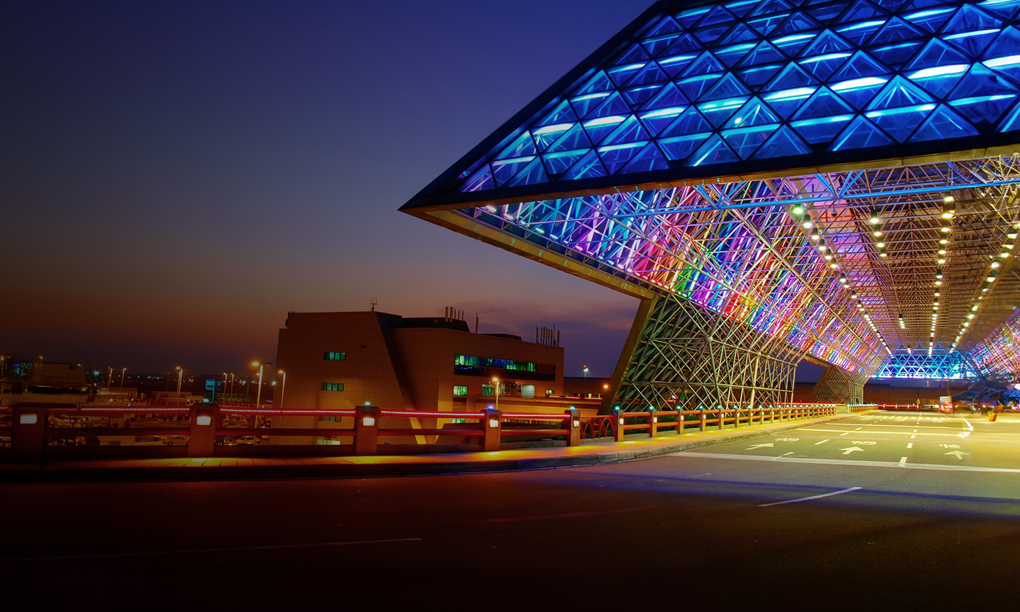 The bustling city night view reveals modern architectural structures along crowded avenues, with traffic streaming across the urban bridge.