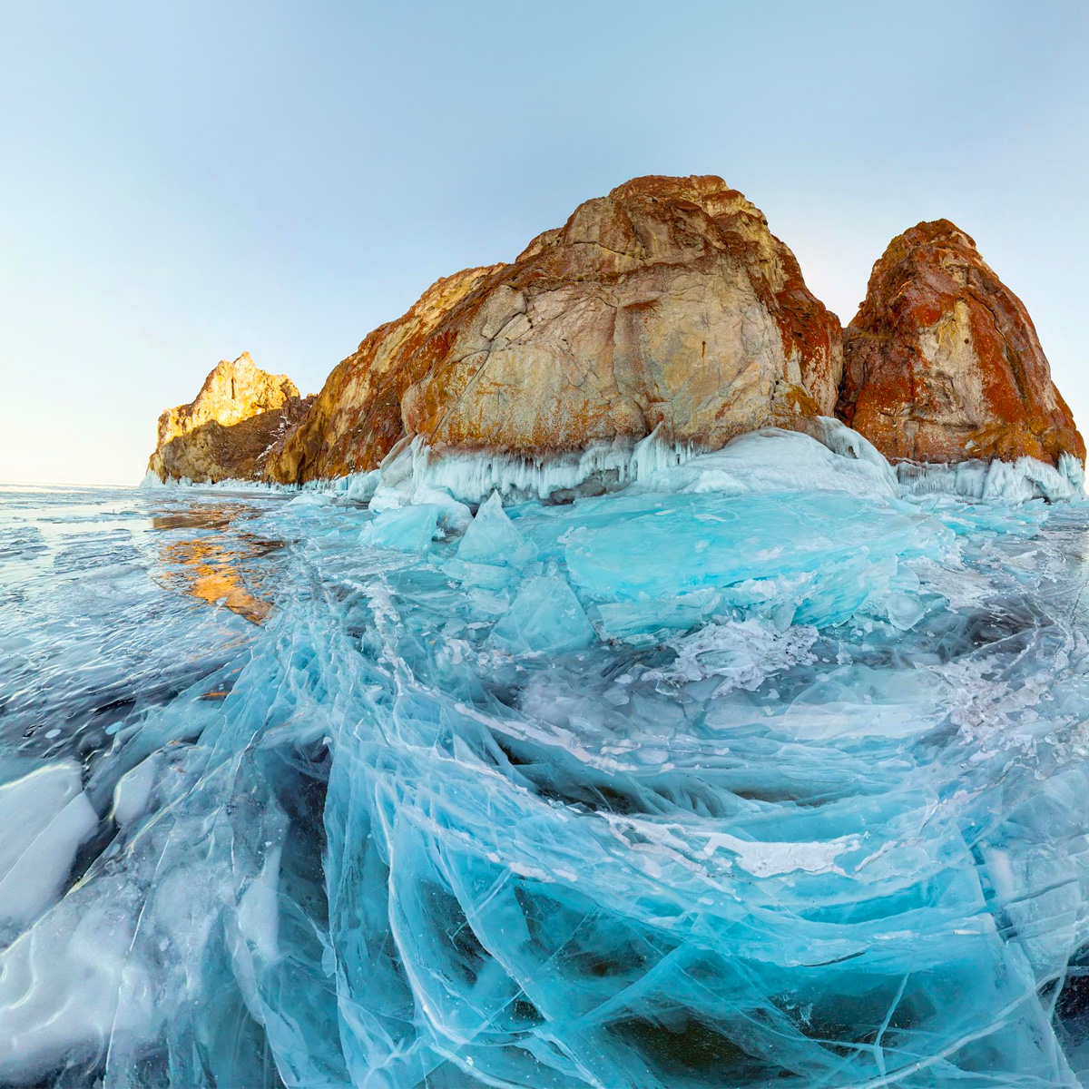 The pristine beach landscape showcases a harmonious blend of rock formations, blue ocean, and the vast sky.