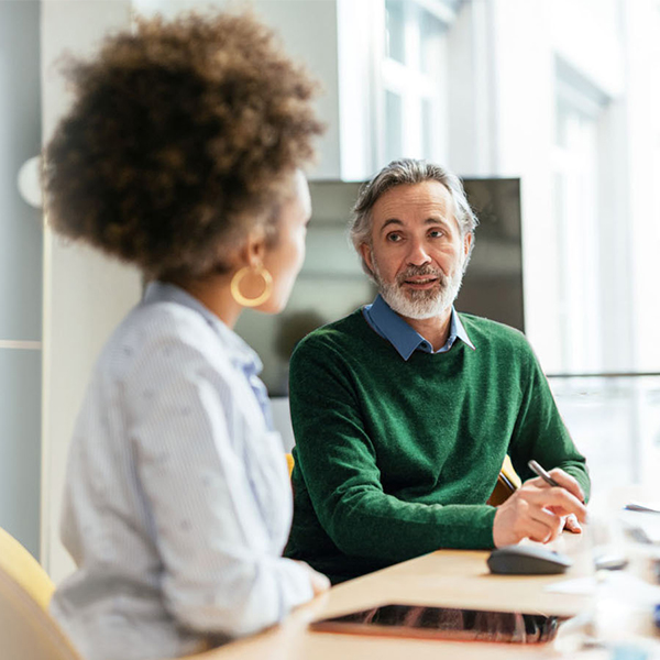 A professional doctor engages in a consultation with a couple in a modern office, addressing essential health-related topics.