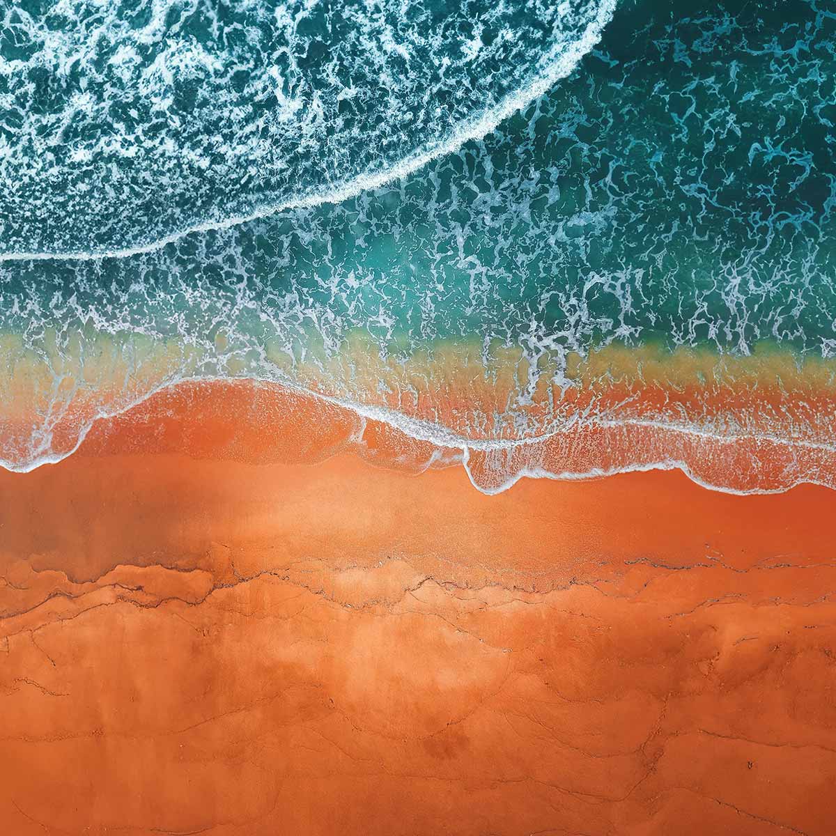 Abstract nature background showcasing the vibrant red and blue textures of the beach, sea, and water.