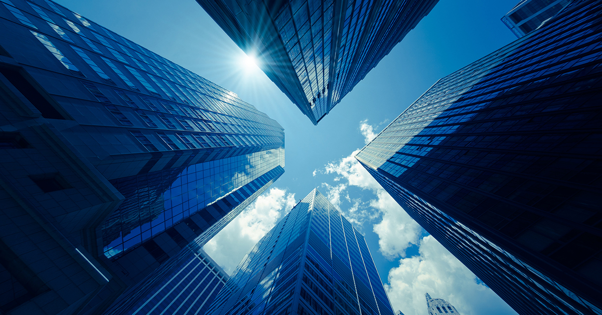 A modern cityscape with glowing skyscrapers set against a blue abstract backdrop showcases contemporary urban design.
