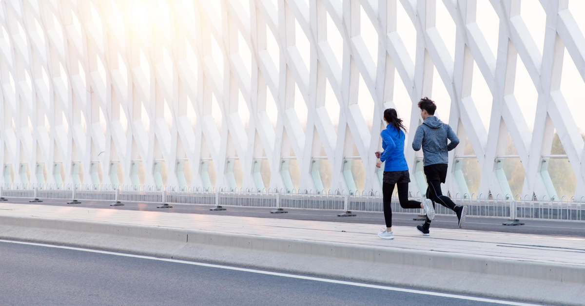 people jogging on a track on a bridge