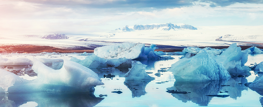 Sustainable investing in a time of climate change Image of partially melted icebergs surrounded by water