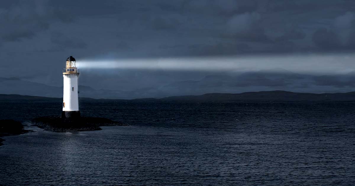 lighthouse shining a light into the sea