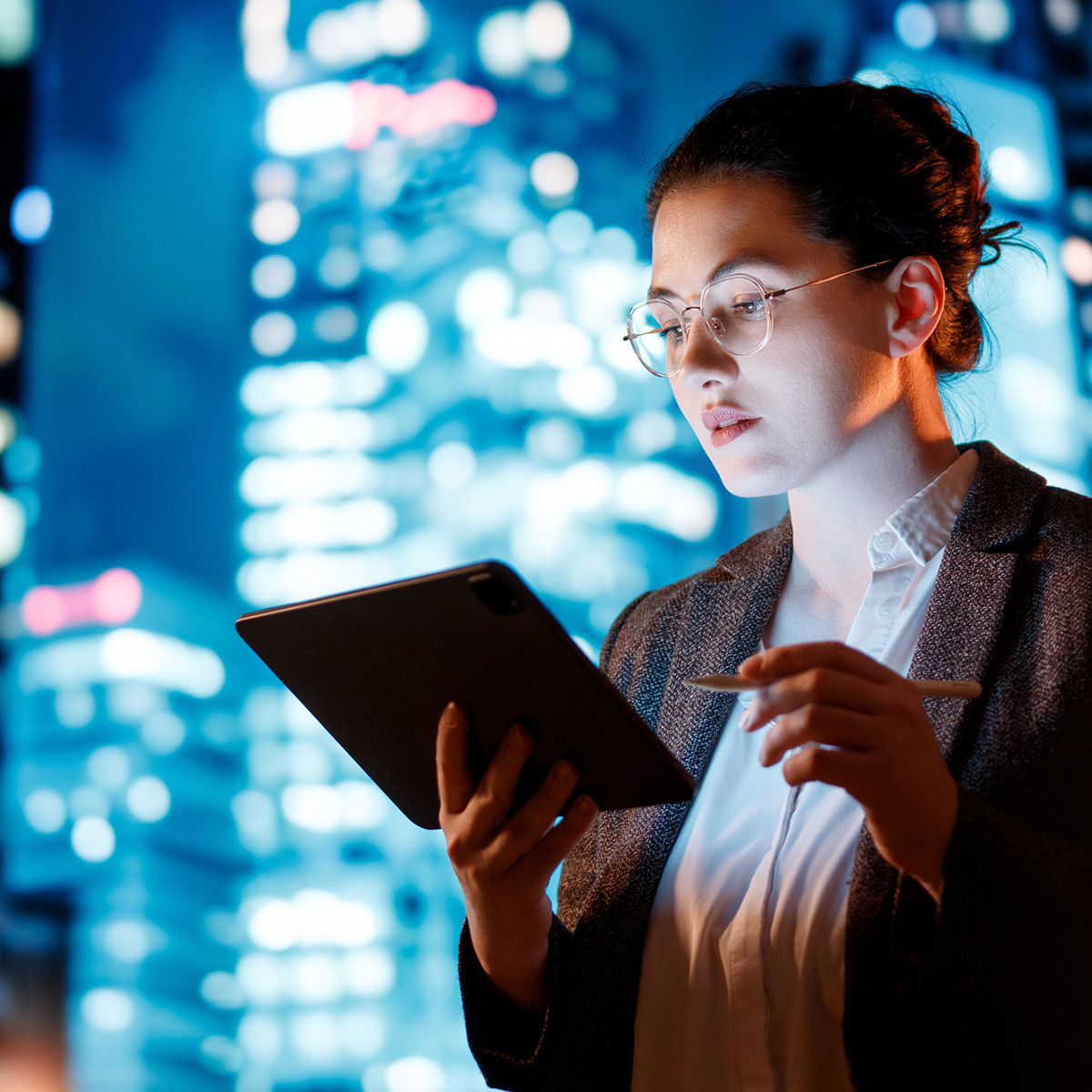 A young businesswoman works diligently on her computer, demonstrating focus and professionalism in a modern workspace.