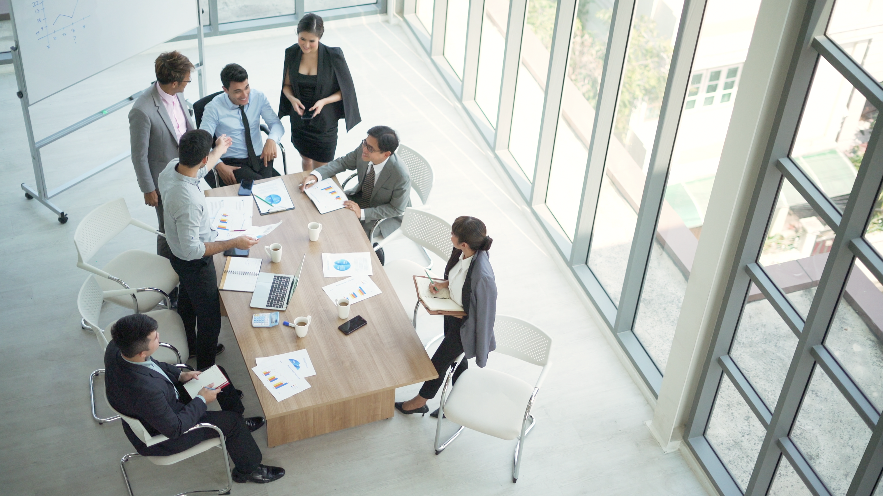 A professional businesswoman engages in a collaborative office meeting with colleagues, fostering teamwork and ideas.