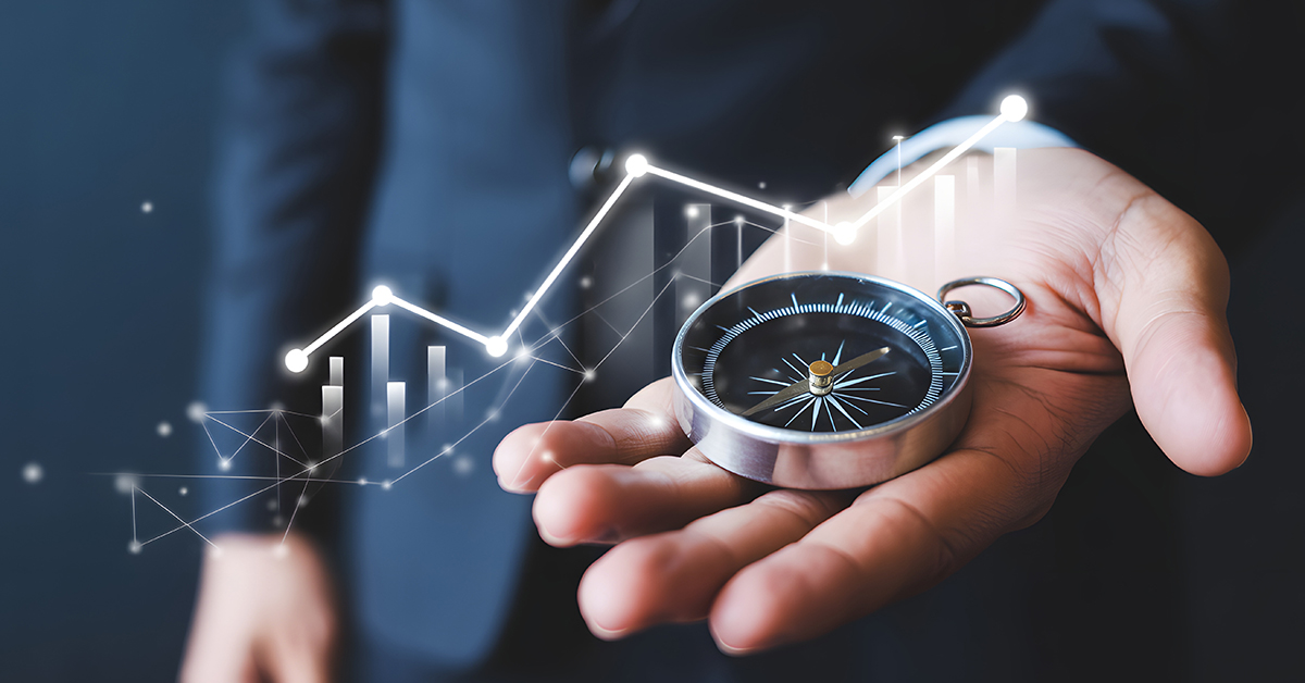 A close‑up of a hand holding a silver compass, with a luminous, ascending line graph and network points overlaid.